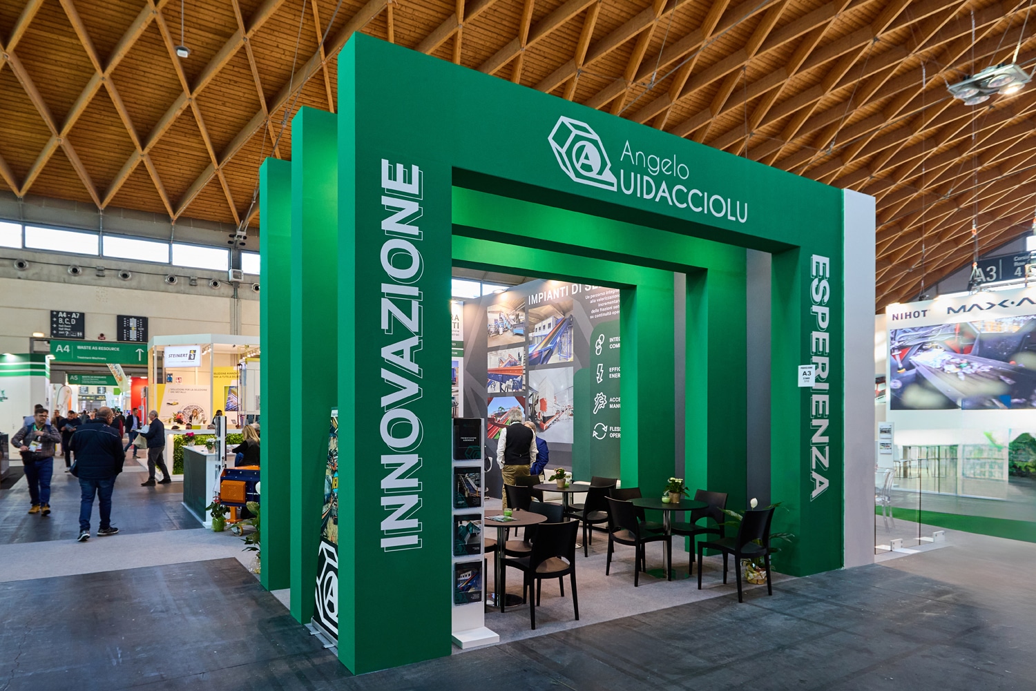 Struttura espositiva a portali sequenziali verdi che donano profondità e visibilità allo stand a Rimini.